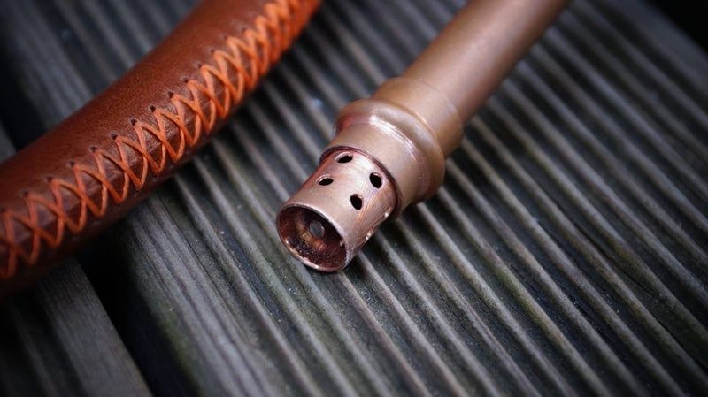 Nahaufnahme zweier brauner Schläuche mit perforiertem Metallanschluss